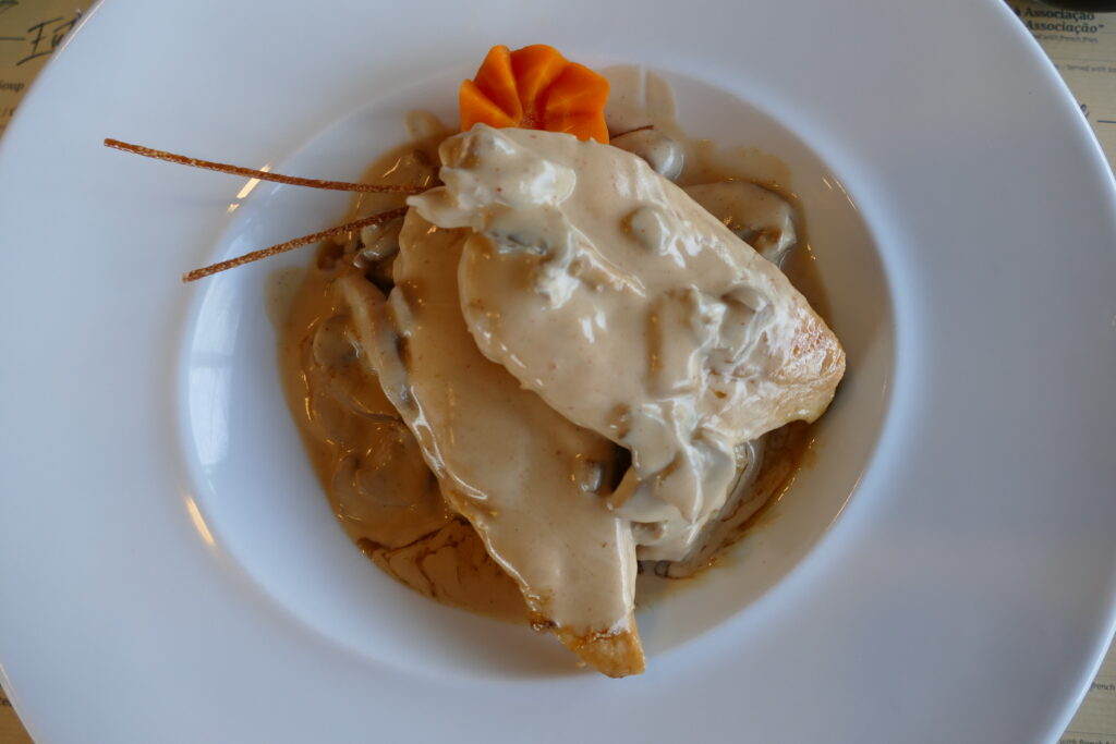 Keto Hähnchenbrust mit cremiger Pilz-Sahnesauce auf weißem Teller